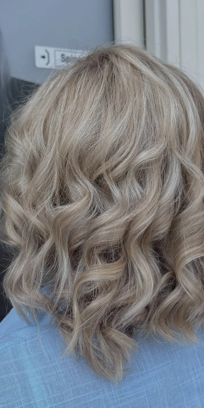 Colore biondo cenere su capelli mossi, vista di spalle